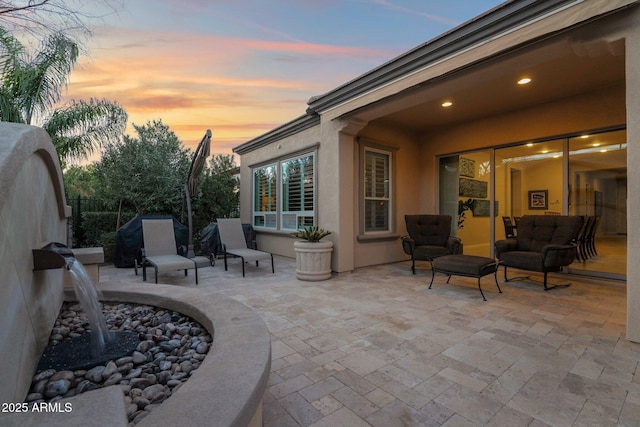 patio terrace at dusk featuring an outdoor living space