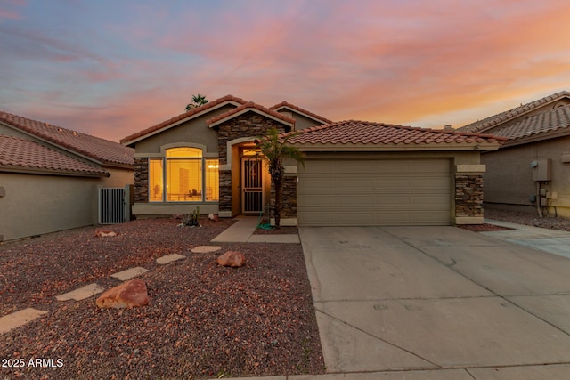 view of front of property with driveway, a garage, a tile roof, and stone siding