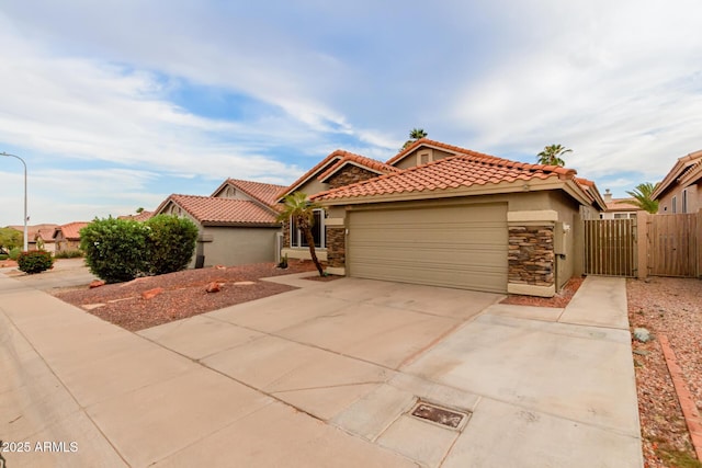 mediterranean / spanish-style home with a garage, stucco siding, driveway, and stone siding