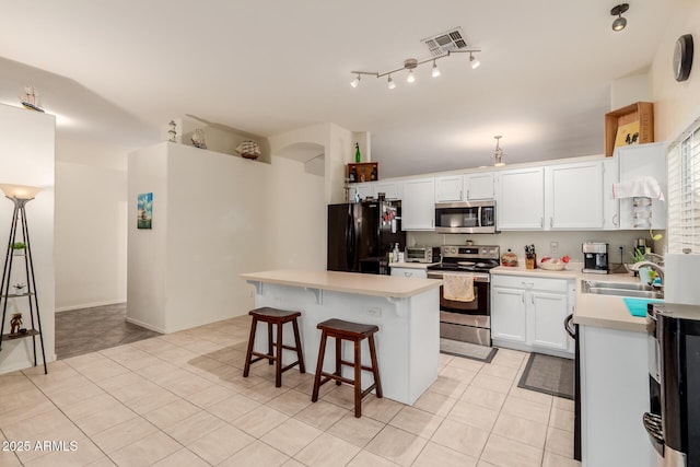 kitchen featuring appliances with stainless steel finishes, light countertops, a sink, visible vents, and light tile patterned flooring