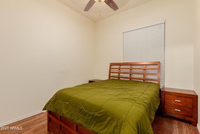 bedroom with ceiling fan, wood finished floors, and baseboards