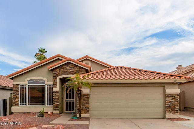 mediterranean / spanish-style house with stucco siding, a garage, concrete driveway, and stone siding