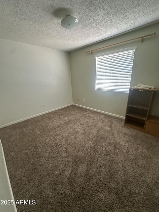 carpeted empty room with a textured ceiling