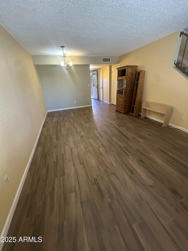 interior space featuring a textured ceiling and dark hardwood / wood-style floors