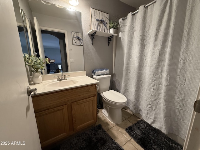 full bathroom featuring tile patterned flooring, curtained shower, vanity, and toilet