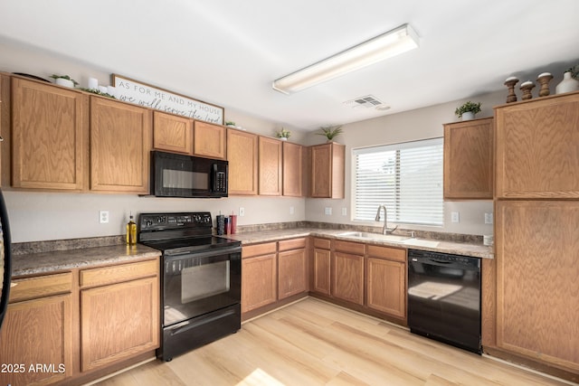 kitchen featuring light wood-type flooring, sink, and black appliances