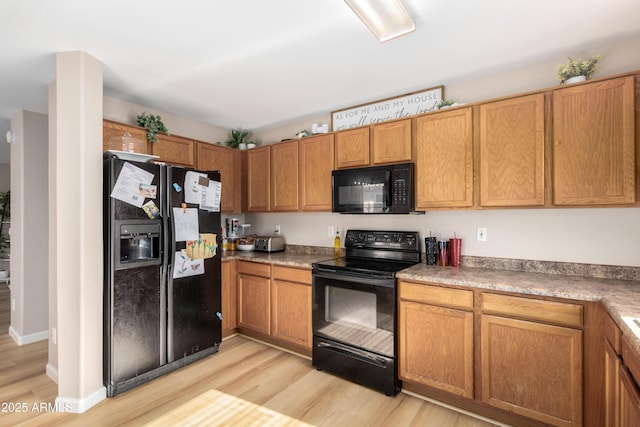 kitchen featuring light wood-type flooring and black appliances