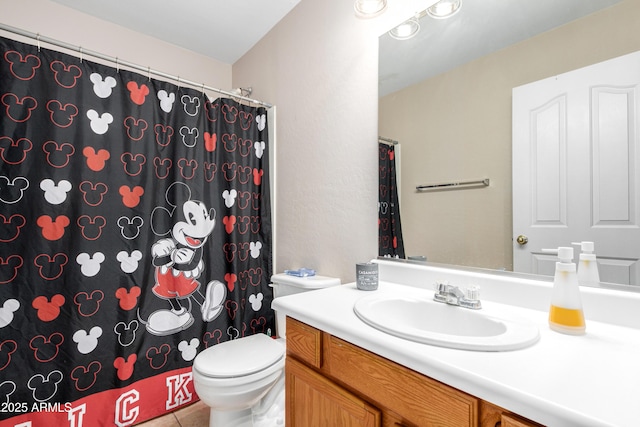 bathroom featuring tile patterned flooring, vanity, and toilet