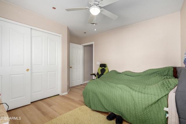 bedroom with light wood-type flooring, a closet, and ceiling fan