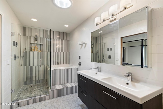 bathroom with tile patterned floors, vanity, an enclosed shower, and tile walls