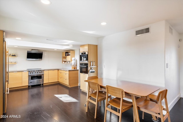 kitchen with high end range, light brown cabinetry, and dark hardwood / wood-style flooring