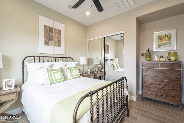 bedroom featuring wood finished floors, visible vents, baseboards, recessed lighting, and a closet