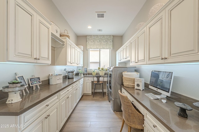 interior space featuring visible vents, recessed lighting, washer and dryer, light wood-style flooring, and cabinet space