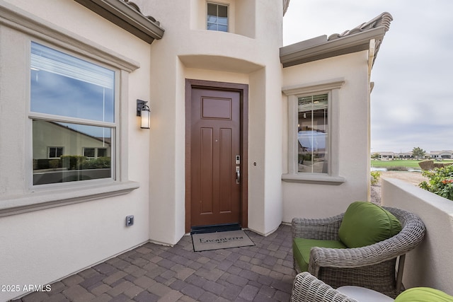 view of exterior entry featuring stucco siding