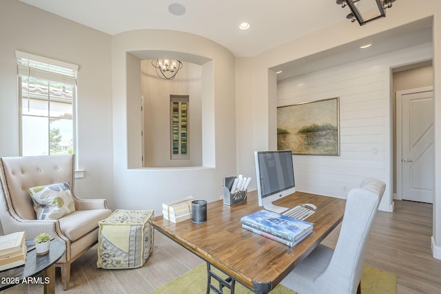 office featuring wood finished floors, recessed lighting, wooden walls, baseboards, and a chandelier