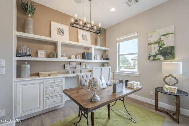 office area with a notable chandelier, light wood-style floors, visible vents, and baseboards