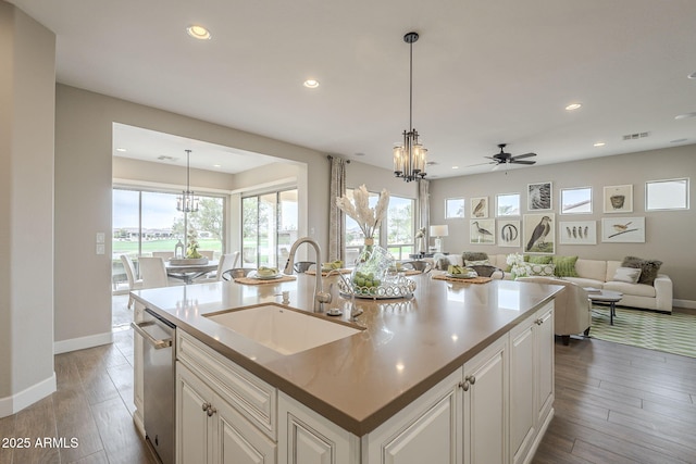 kitchen with a center island with sink, recessed lighting, a sink, light wood-style floors, and decorative light fixtures