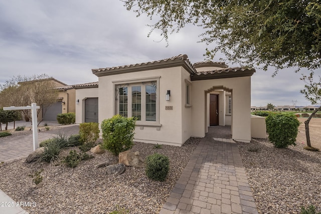 view of front of home featuring stucco siding, fence, and a tiled roof