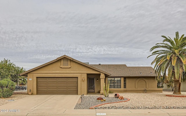 view of front of home with stucco siding, an attached garage, and concrete driveway