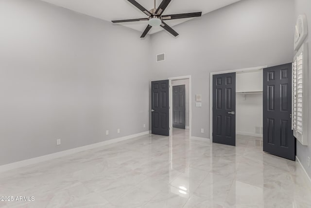 unfurnished bedroom with a high ceiling and ceiling fan