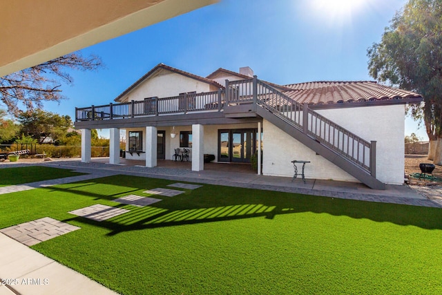 rear view of house with a deck, a yard, and a patio