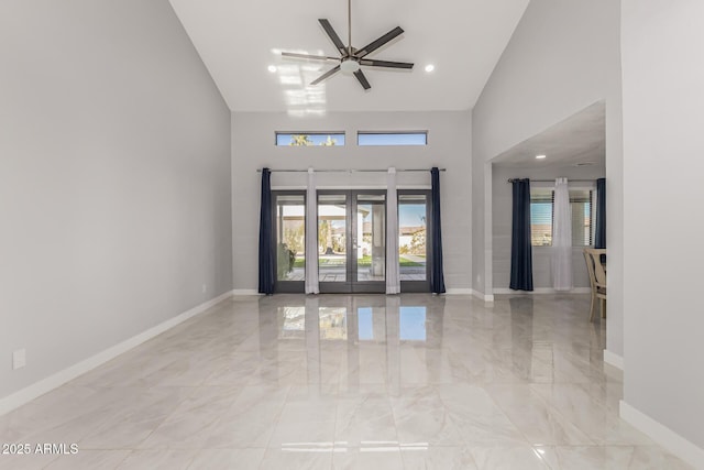 interior space featuring ceiling fan, french doors, and a towering ceiling