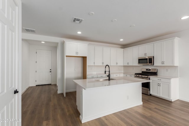 kitchen featuring stainless steel appliances, sink, a center island with sink, and white cabinets