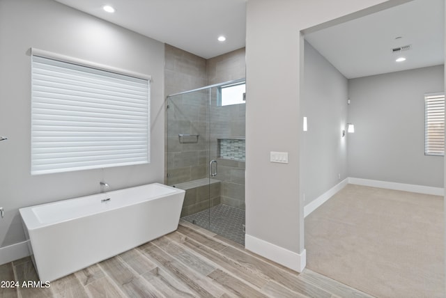 bathroom featuring hardwood / wood-style flooring and independent shower and bath