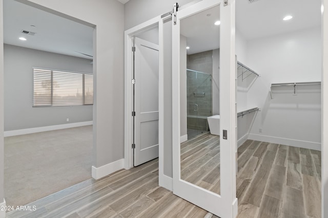 interior space featuring a shower with shower door and wood-type flooring