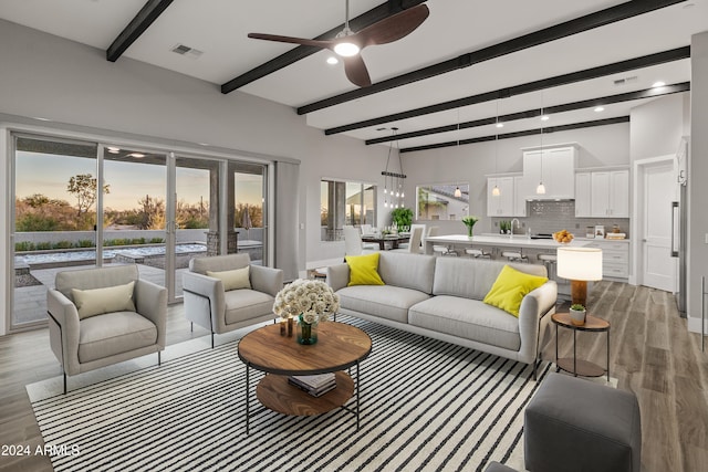 living room with dark hardwood / wood-style floors, beam ceiling, and ceiling fan