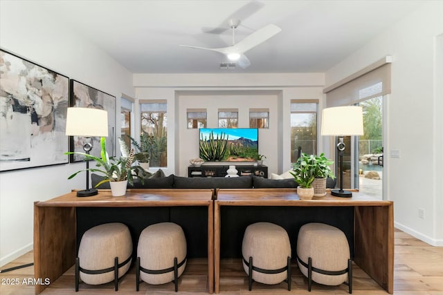 home office featuring visible vents, light wood-style flooring, baseboards, and ceiling fan