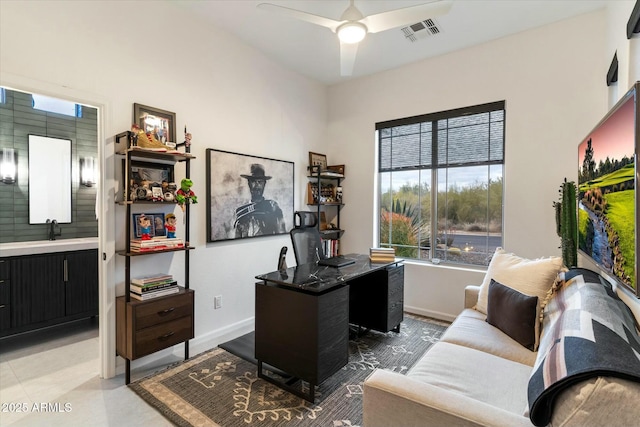 office space featuring visible vents, baseboards, ceiling fan, and a sink