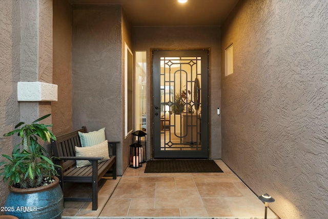 doorway to property featuring stucco siding