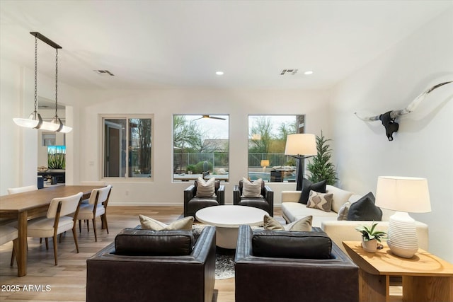 living area with recessed lighting, visible vents, baseboards, and light wood-style flooring