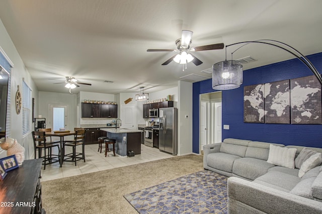 living area with light tile patterned flooring, visible vents, light colored carpet, and a ceiling fan