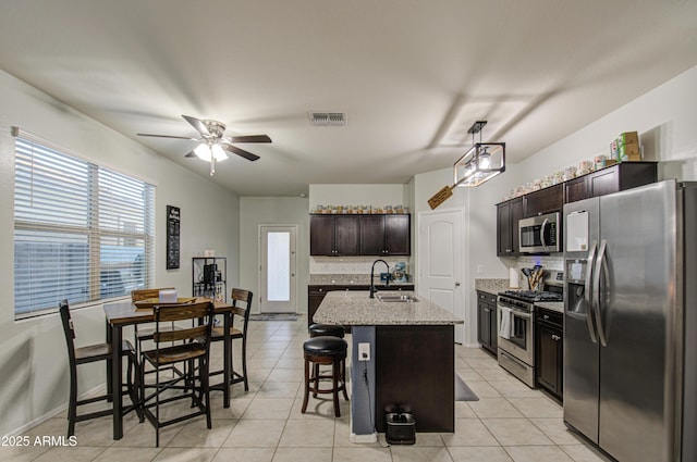 kitchen featuring tasteful backsplash, visible vents, appliances with stainless steel finishes, light tile patterned flooring, and a sink