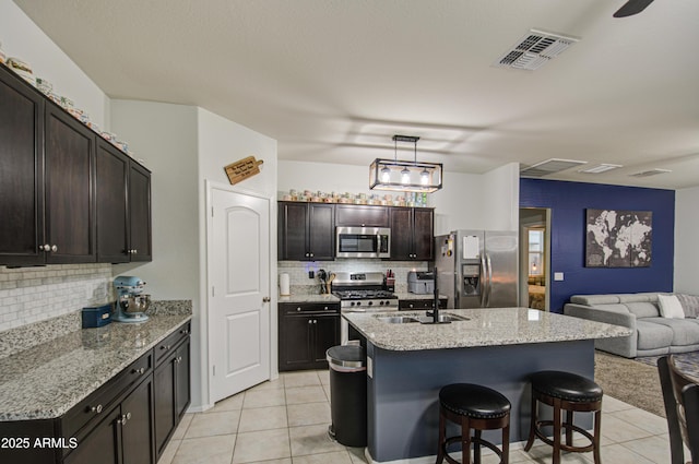 kitchen with visible vents, open floor plan, light tile patterned floors, appliances with stainless steel finishes, and a sink