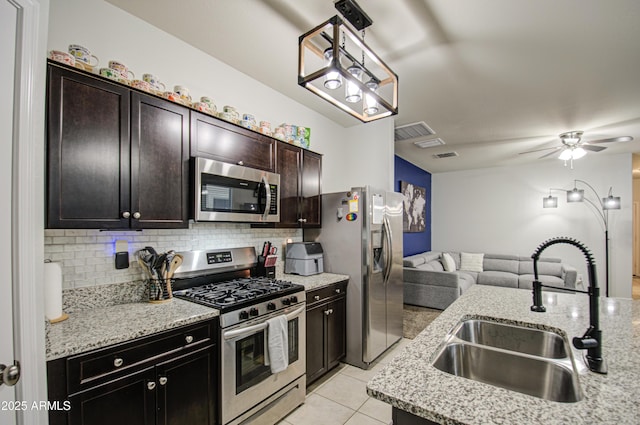 kitchen featuring tasteful backsplash, visible vents, open floor plan, appliances with stainless steel finishes, and a sink