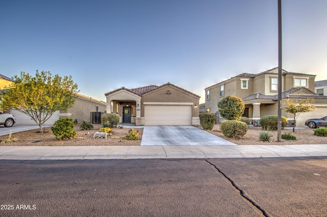 view of front facade featuring stucco siding, a garage, concrete driveway, and a tile roof