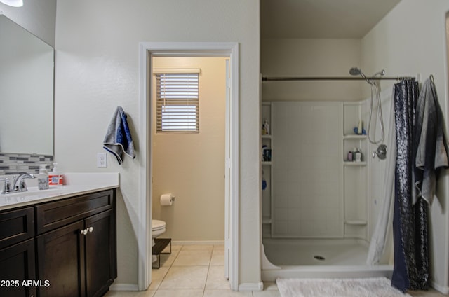 full bathroom with vanity, a shower stall, tile patterned floors, toilet, and tasteful backsplash