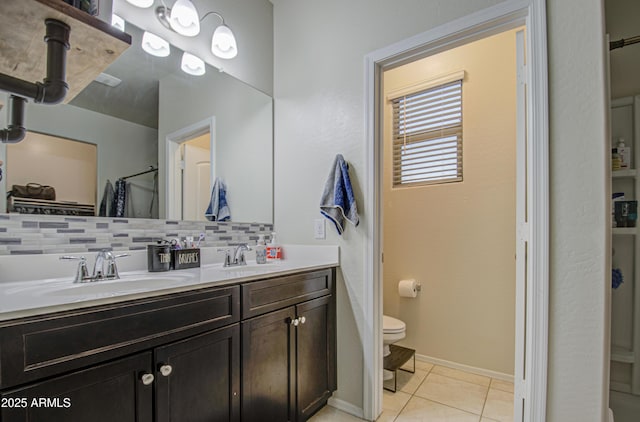 full bath with tile patterned floors, decorative backsplash, toilet, and a sink