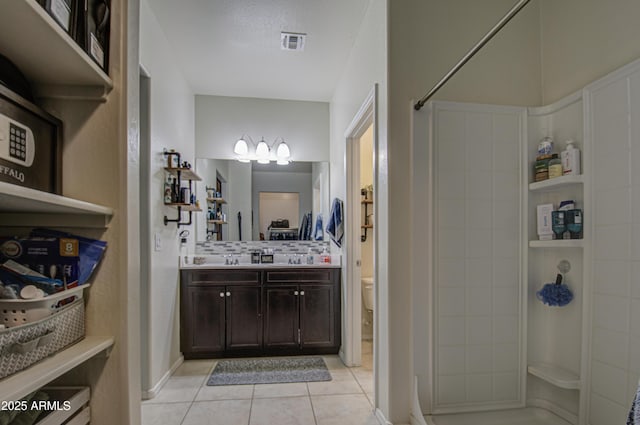 full bathroom with vanity, visible vents, a tile shower, tile patterned flooring, and toilet