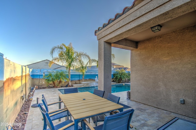 view of patio / terrace with outdoor dining space, an outdoor pool, and a fenced backyard