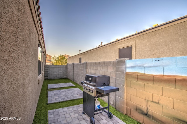 view of patio with area for grilling and a fenced backyard