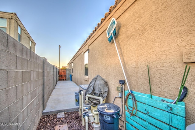 exterior space featuring stucco siding, a patio area, and fence