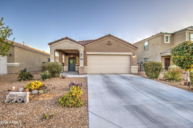 mediterranean / spanish-style house with a tiled roof, a garage, driveway, and stucco siding