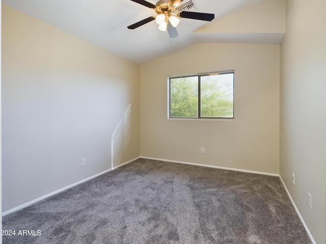 carpeted spare room featuring ceiling fan and vaulted ceiling