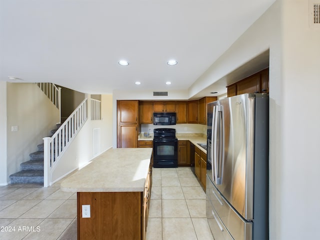 kitchen with a center island, light tile patterned flooring, and black appliances