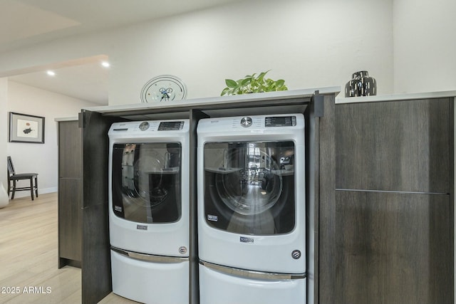 laundry area with washer and clothes dryer and light wood-type flooring