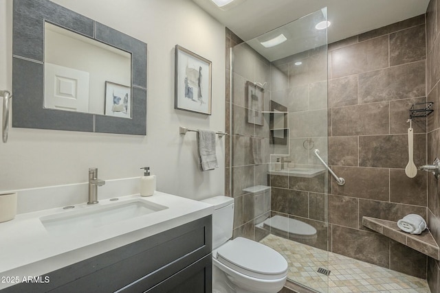 bathroom with vanity, toilet, and a tile shower